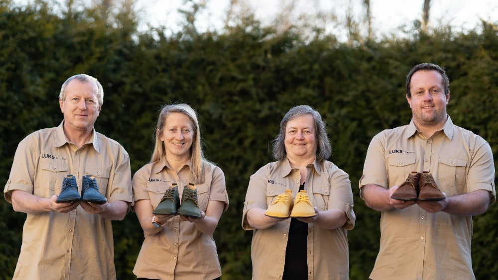 The four members of the LUKS family holding shoes they make