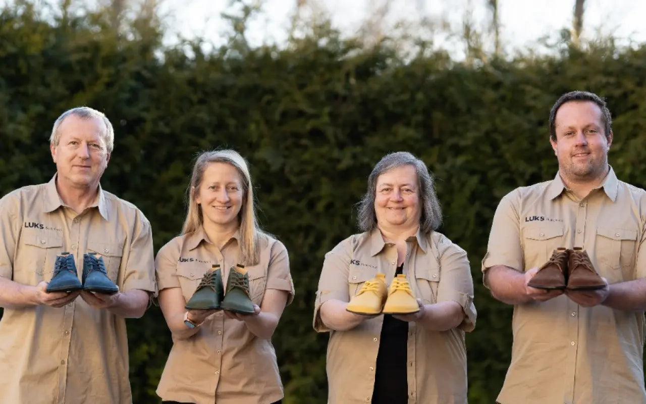 The LUKS Barefoot family team holding handmade shoes