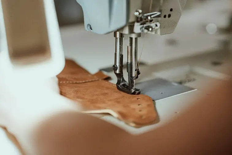 Leather shoe pieces being sewn in the LUKS family workshop